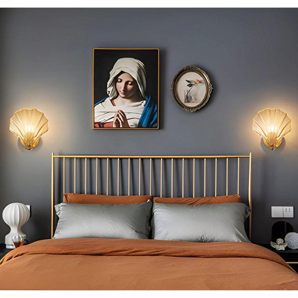 Zwei Wandleuchten aus Muschelholz hängen neben einem Bilderrahmen in einem Schlafzimmer