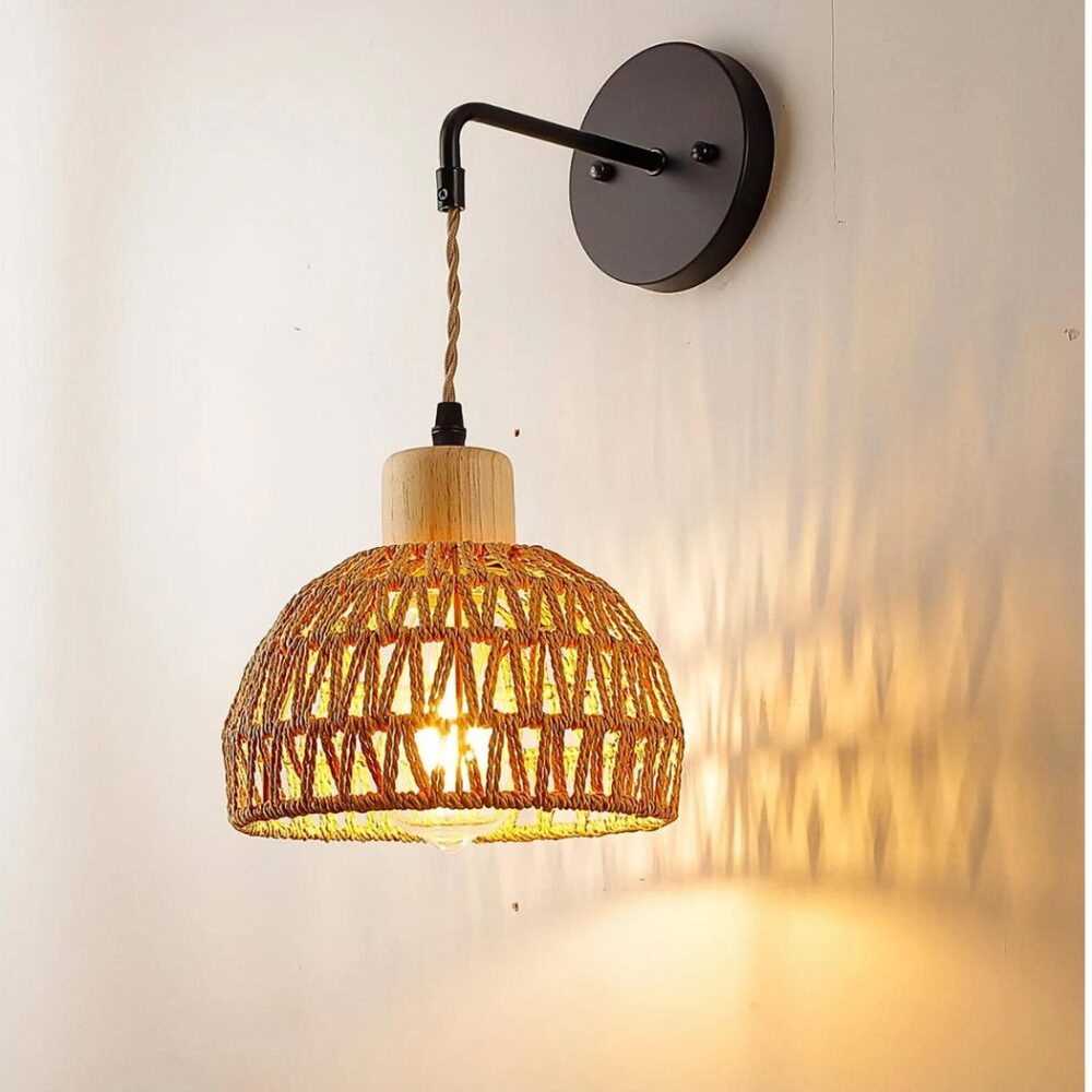 man sieht an einer hellgrauen Wand eine Wandleuchte aus Rattan im Bohème-Stil