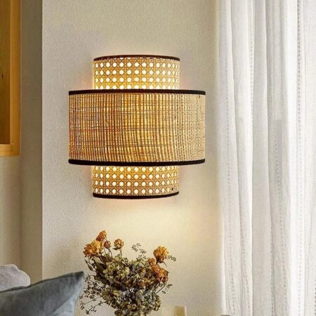 wir sehen eine Wandleuchte aus Rattanrohr an einer hellen Wand im Vintage-Stil