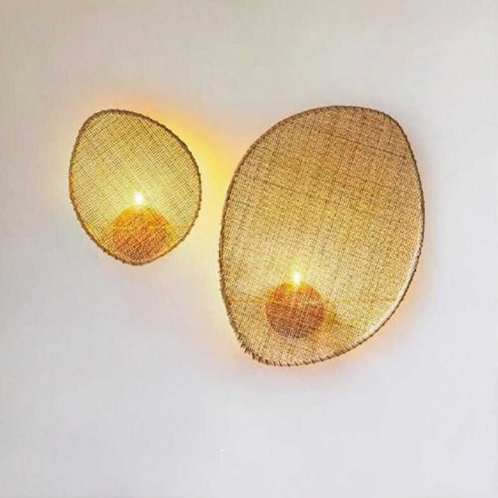 man sieht an einer hellgrauen Wand zwei Wandleuchten aus Rohrgeflecht im Bohème-Stil