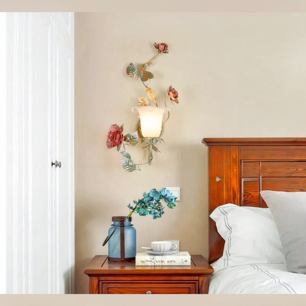 Schmiedeeiserne Wandleuchte in Form einer romantischen Blume, die an einer beigen Wand in einem Schlafzimmer und neben dem Bett hängt.