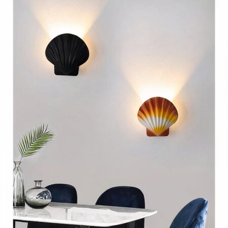 in einem Wohnzimmer mit grauen Wänden sieht man zwei Wandleuchten in Form von Jakobsmuscheln, eine braune und eine schwarze