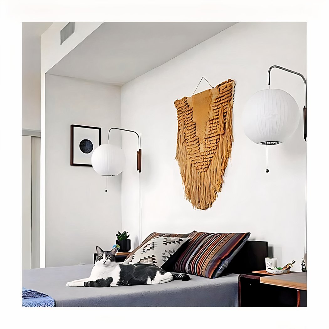 man sieht in einem Zimmer mit weißen Wänden eine minimalistische weiße Wandleuchte im japanischen Stil