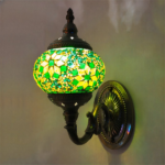 Eine orientalische Wandleuchte mit grünen und gelben Blumen an einer Wand befestigt