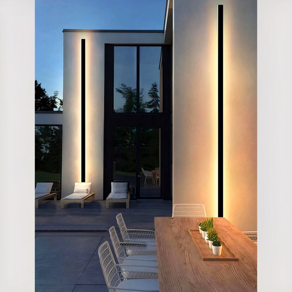 Solar-Wandleuchte mit schlichtem Design, die an einer Terrassenwand hängt und eingeschaltet ist.