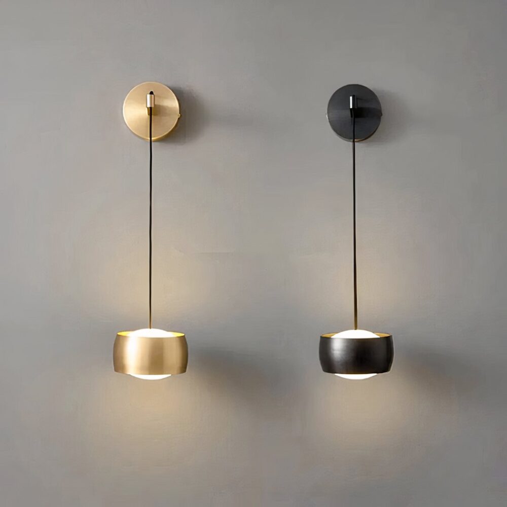 Hängende Design-Wandleuchte aus schwarzem oder goldfarbenem Messing in den Ausführungen schwarz und gold, die eingeschaltet und an einer grauen Wand befestigt werden.