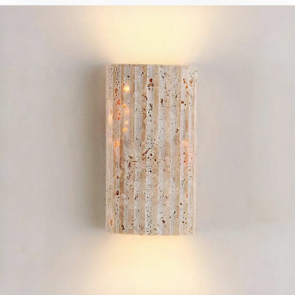 man sieht an einer hellgrauen Wand eine vertikale Wandleuchte aus Naturstein im Bohemian Style