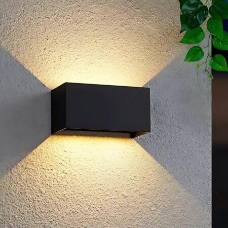 Wandleuchte Außenleuchte mit doppeltem Lichtstrahl Wandleuchte für den Außenbereich mit zwei Lichtstrahlen in schwarzer, rechteckiger Form. Wird an einer beigen Außenwand befestigt und eingeschaltet.