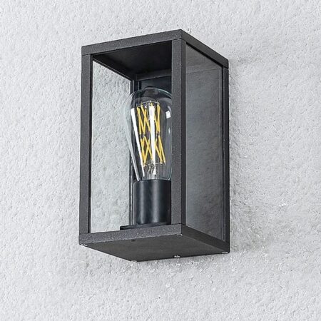 Wandleuchte Außenleuchte mit sichtbarer Glühbirne Wandleuchte für den Außenbereich mit sichtbarer Glühbirne in Form eines Kastens mit schwarzen Metallkonturen, bei dem die ausgeschaltete Glühbirne sichtbar ist. Wird an einer weißen Außenwand befestigt.
